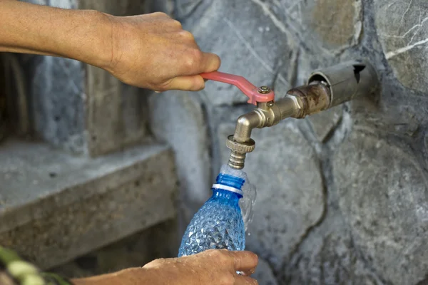 Mãos a tirar água fresca de uma fonte de água potável — Fotografia de Stock