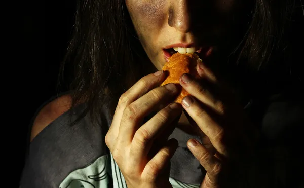 Бедная грязная девчонка ест хлеб. Лицензионные Стоковые Фото