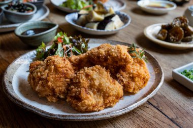 Tonkatsu ya da kızarmış domuz eti, geleneksel bir Japon yemeği, arka planda çeşitli Japon yemekleri var..