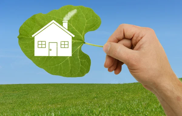 Hand holding leaf with house — Stock Photo, Image