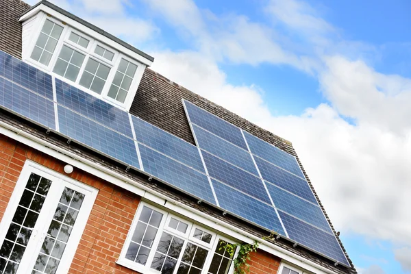 Çatıda güneş panelleri olan ev.