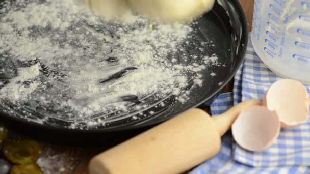 Poner pastel de trompeta en una sartén de pan. aparte de cáscaras de huevo, rodillo y jarra de medición . — Vídeos de Stock