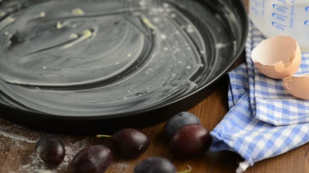 Putting flour in loaf pan with butter ready to baking plum crumpet cake — Stock Video