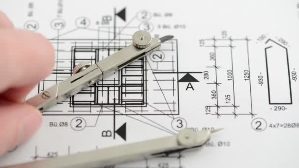 Check the measurements and dimensions on the blueprint with the compass — Stock Video