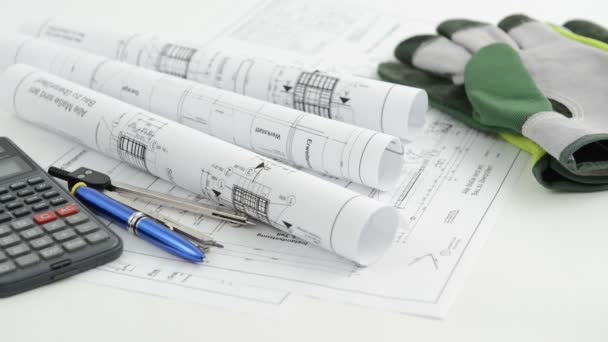 Architectural drawing blueprint with calculator pen and work gloves — Stock Video