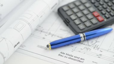 hesap makinesi ve kalem ile mimari çizim planı