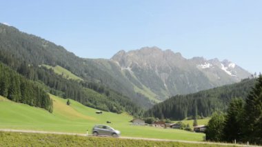 Cars pass by on a street at Schönachtal (Schoenach Valley, Austria)