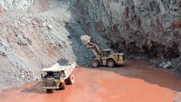 Earth mover ready to loading a dumper truck in a quarry — Stock Video