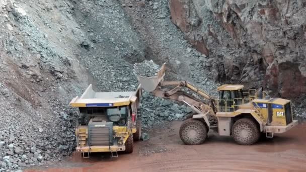 Earth mover ready to loading a dumper truck in a quarry — Stock Video