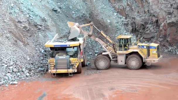 Earth mover ready to loading a dumper truck in a quarry — Stock Video