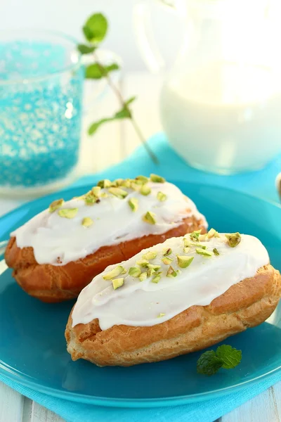 Eclairs with pistachio cream on the blue