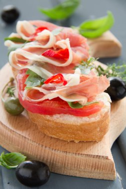 Bruschetta jambon, domates ve fesleğen ile.