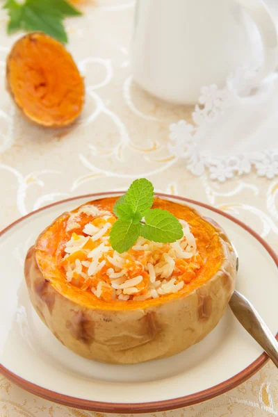 Gachas de arroz con calabaza al horno en una calabaza . — Foto de Stock