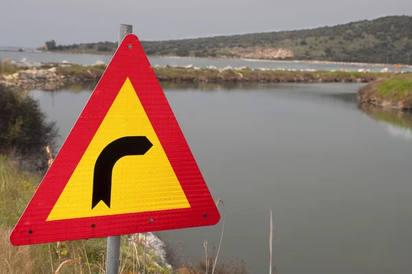 Traffic sign pointing right towards a water canal — Stock Photo, Image