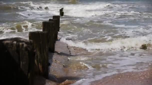 Costa do mar com uma fileira de pilhas — Vídeo de Stock