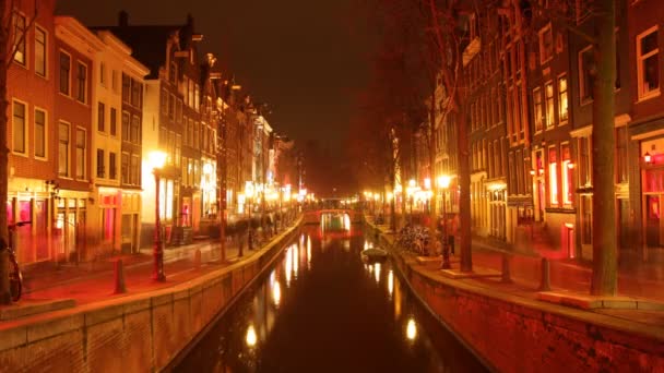 Reflection in canal of red light district neon lights, amsterdam — стоковое видео