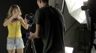 seksi güzel sarışın kadın danslar ve pozlar için bir fotoğrafçı, kameraman