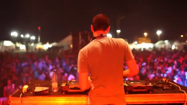 Vista de trás de um DJ olhando para a multidão em um festival — Vídeo de Stock