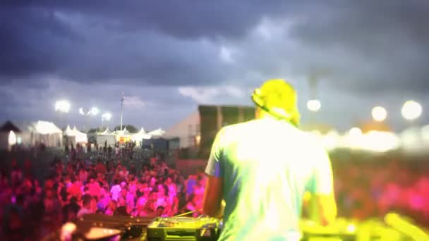 Zeitraffer-Blick von hinten auf einen DJ, der auf einem Festival in die Menge schaut — Stockvideo