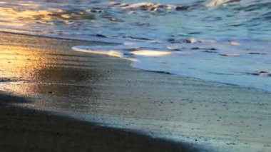 Dalgalar güneş ışığı yansımaları ile plaj üzerine alıştırma