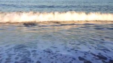 Dalgalar güneş ışığı yansımaları ile plaj üzerine alıştırma