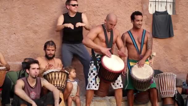 Bubeníci hrají na pláži benirras v ibiza jako slunce začíná. — Stock video