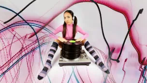 Hermosa mujer sexy se sienta detrás de una creciente pila de registros en un tocadiscos — Vídeo de stock