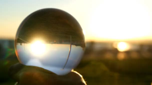 Une fille joue contact jongler avec une boule transparente en verre 