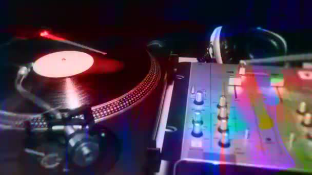 Ein Schwenk über DJ-Plattenspieler mit abstrakten Lichtmustern überlagert — Stockvideo
