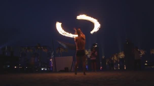 Человек на фестивале играет с огненными палками — стоковое видео