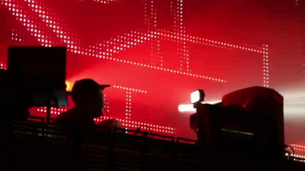 Shot of a dj looking playing at a festival in front of a huge led screen — Stock Video