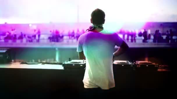 Blick von hinten auf einen DJ, der auf einem Festival in die Menge blickt — Stockvideo