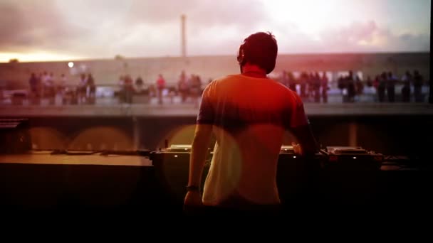 Blick von hinten auf einen DJ, der auf einem Festival in die Menge blickt — Stockvideo