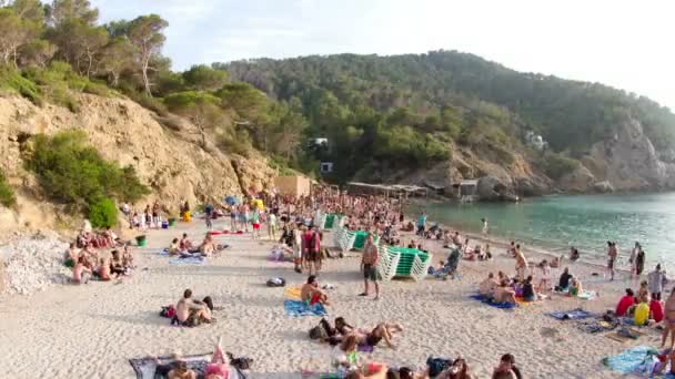 Menschenmassen versammeln sich am berühmten Strand von Benirras in Ibiza — Stockvideo