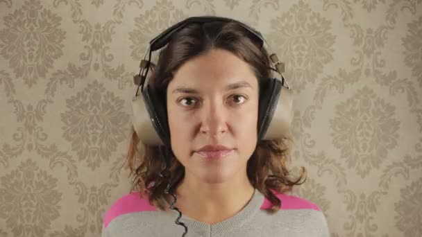 Cute woman wearing different retro headphones — Stock Video