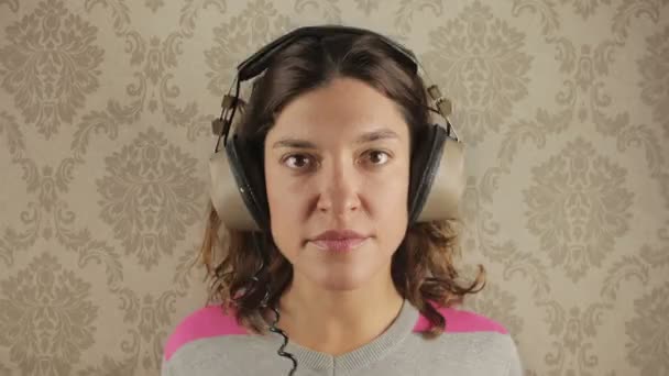 Cute woman wearing different retro headphones — Stock Video