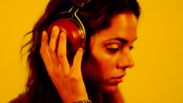 Närbild av vacker ung kvinna som lyssnar på musik i hörlurar — Stockvideo