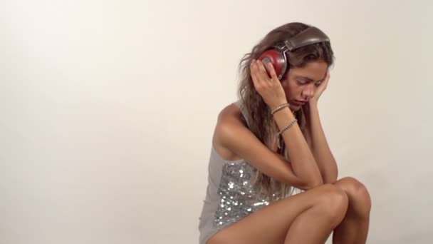美丽的年轻女子，听听音乐头戴式耳机的特写 — 图库视频影像