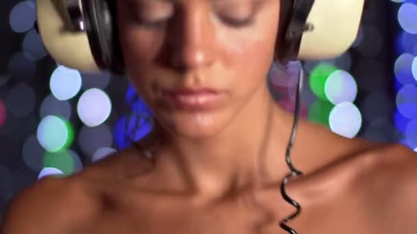 Sexy weiblicher DJ tanzt und spielt Platten, mit funkelndem Disco-Hintergrund — Stockvideo