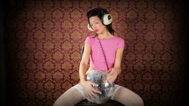 Μια σούπερ σέξι γυναίκα χορεύει κρατώντας ένα discoball και φορώντας ακουστικών — Αρχείο Βίντεο
