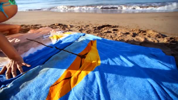 Beautiful girl sunbaths on the beach in a bikini at sunrise — Stock Video
