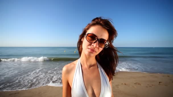 En vakker jente danser på stranden i bikini ved soloppgang. – stockvideo