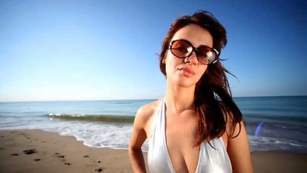 Beautiful girl dances on the beach in a bikini at sunrise — Stock Video