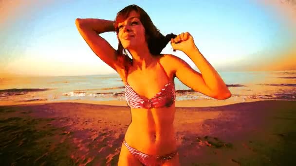 Belle fille danse sur la plage en bikini au lever du soleil 