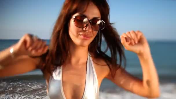 Beautiful girl dances on the beach in a bikini at sunrise — Stock Video