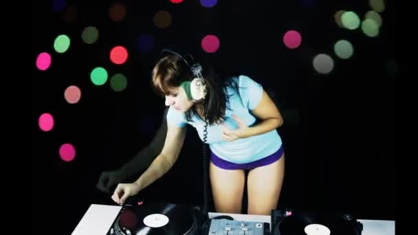 Linda jovem dj feminino, atrás dos conveses em um clube — Vídeo de Stock