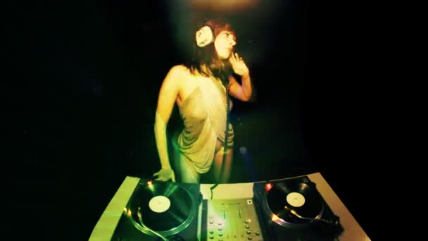 Linda jovem dj feminino, atrás dos conveses em um clube — Vídeo de Stock