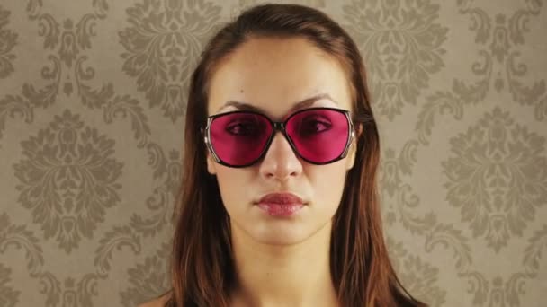 Detención de una mujer bonita con diferentes gafas de sol retro — Vídeo de stock