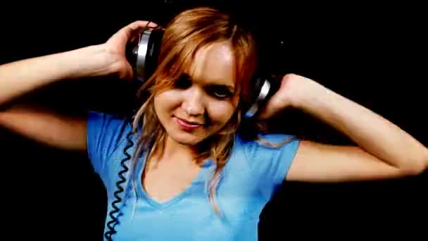 Красива молода блондинка танцює в щільному верхньому куті і навушники — стокове відео