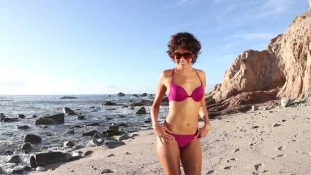 Красивая девушка танцует на пляже в бикини на рассвете — стоковое видео